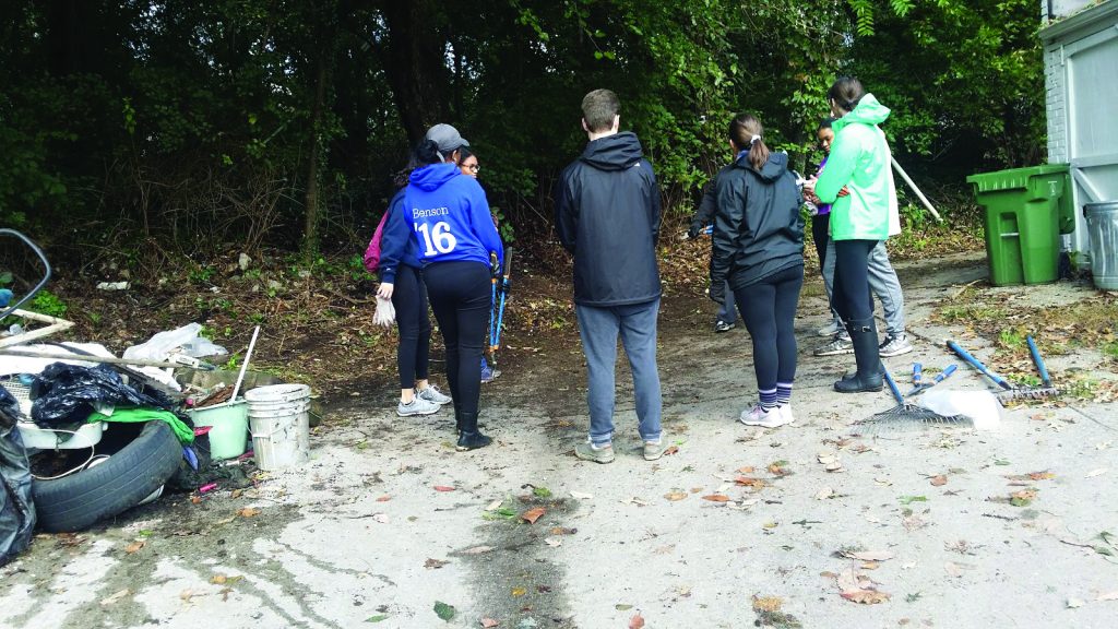 Estudiantes de la Universidad de Loyola y Friends of Springfield Woods limpian y restauran la pequeña área boscosa en Baltimore.