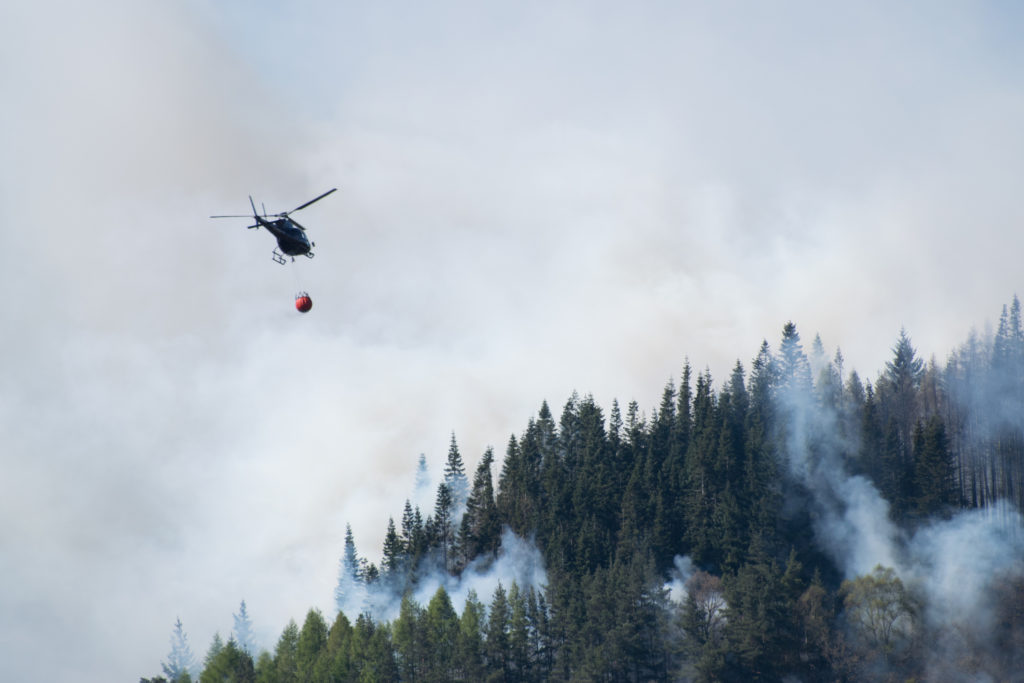 Helicóptero tirando agua para extinguir incendios forestales